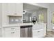 Stainless steel dishwasher and sink with view of the living room in this bright and airy kitchen at 42 Chris Todd Way, Angier, NC 27501