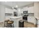 Modern kitchen featuring white cabinets, stainless steel appliances, and a center island with seating at 42 Chris Todd Way, Angier, NC 27501