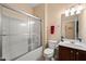 Bright bathroom featuring a shower-tub combo with glass doors, and a vanity with ample lighting at 463 Kerriann Ln, Clayton, NC 27520
