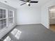 A spacious bedroom with neutral carpet, ceiling fan, natural light and a view into the adjoining bathroom at 4842 Wyatt Brook Way, Raleigh, NC 27609
