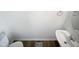 A well-lit powder room with wood-look flooring, a white pedestal sink, and a modern towel ring at 4842 Wyatt Brook Way, Raleigh, NC 27609