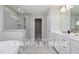 Elegant bathroom featuring a glass enclosed shower, a soaking tub, and a white vanity with double sinks and chrome fixtures at 5036 Trotter Dr, Raleigh, NC 27603
