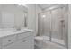 Modern bathroom featuring a sleek vanity, tiled shower with glass doors, and ample lighting at 5036 Trotter Dr, Raleigh, NC 27603