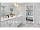 Well-lit bathroom featuring a double vanity with a view into the bright, carpeted bedroom at 5036 Trotter Dr, Raleigh, NC 27603