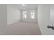 Simple bedroom featuring neutral carpet and two windows providing natural light and neighborhood views at 5036 Trotter Dr, Raleigh, NC 27603