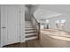 Inviting entryway featuring wood stairs with rod iron spindles, wood floors, and a view of the kitchen at 5036 Trotter Dr, Raleigh, NC 27603