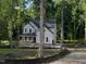 Two-story home under construction, showcasing a covered front porch and a partially wooded lot at 5036 Trotter Dr, Raleigh, NC 27603