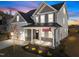 Charming two-story home with a covered porch, brick accents, attached garage and landscaped front yard with American flag at 5036 Trotter Dr, Raleigh, NC 27603