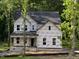 Close up of a two-story home under construction featuring a covered front porch and large windows at 5036 Trotter Dr, Raleigh, NC 27603