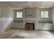 Living room with a fireplace and custom built-in cabinets under two large windows at 5036 Trotter Dr, Raleigh, NC 27603