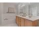 Bathroom featuring a double vanity, soaking tub, and ample lighting at 534 Ives Ct, Chapel Hill, NC 27514