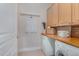 Functional laundry room with washer, dryer, wooden countertops, and overhead cabinets at 534 Ives Ct, Chapel Hill, NC 27514