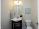 Powder room featuring pedestal sink, modern fixtures, framed mirror, and neutral decor at 5421 Downton Grove Ct, Fuquay Varina, NC 27526