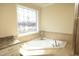 Close up on the bathtub in a bathroom with a stained glass window and granite countertops at 5421 Downton Grove Ct, Fuquay Varina, NC 27526
