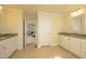 A spacious bathroom with double sinks, granite countertops, and doorway view into the bedroom at 5421 Downton Grove Ct, Fuquay Varina, NC 27526