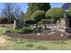 Elegant entrance featuring a pond with waterfall, landscaping, and neighborhood sign at 5421 Downton Grove Ct, Fuquay Varina, NC 27526