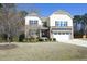Attractive two-story home featuring a stone facade, two car garage, and well-maintained lawn at 5421 Downton Grove Ct, Fuquay Varina, NC 27526