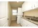 A functional laundry area with stacked washer/dryer and a granite countertop sink at 5421 Downton Grove Ct, Fuquay Varina, NC 27526