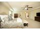 Spacious main bedroom featuring large windows, ceiling fan, and entryways to other rooms at 5421 Downton Grove Ct, Fuquay Varina, NC 27526