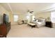 A spacious main bedroom with a ceiling fan, sitting area, and decorative tray ceiling at 5421 Downton Grove Ct, Fuquay Varina, NC 27526