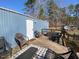 Relaxing outdoor deck area with seating, grill, and wooded views, perfect for unwinding at 55 Waters Edge Loop, Henderson, NC 27537