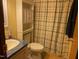 Bathroom features a shower with a plaid curtain, a sink, and a toilet at 55 Waters Edge Loop, Henderson, NC 27537