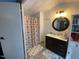 Bathroom featuring a vanity with sink, a round mirror, and a shower with curtain at 55 Waters Edge Loop, Henderson, NC 27537