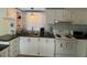 Bright kitchen featuring white cabinets and appliances, dark countertops, and a window at 55 Waters Edge Loop, Henderson, NC 27537