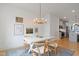 Open-concept dining room with modern chandelier, seating for four, and views into the kitchen at 662 Vine Pkwy, Pittsboro, NC 27312