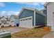 A detached garage shows teal siding and a white garage door with the home visible in the background at 662 Vine Pkwy, Pittsboro, NC 27312