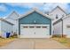 A detached one-car garage with teal siding and a white door is featured in this image at 662 Vine Pkwy, Pittsboro, NC 27312