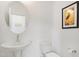 Clean powder room features a white pedestal sink, toilet, and art, offering a simple yet elegant space at 662 Vine Pkwy, Pittsboro, NC 27312
