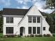 Charming two-story white brick home with a black roof, complemented by colorful flowerbeds and lush green lawn at 68 Alex Farm Ct # 23, Zebulon, NC 27597