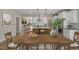 Bright dining area showcases a wooden table, chairs, and stylish light fixtures, next to a modern open kitchen at 69 Alex Farm Ct # 21, Zebulon, NC 27597