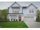 Charming two-story white farmhouse with a bright red front door and well-manicured lawn at 69 Alex Farm Ct # 21, Zebulon, NC 27597