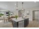 Open kitchen island with seating, stainless steel appliances, pendant lights, and natural wood floors at 69 Alex Farm Ct # 21, Zebulon, NC 27597