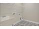 Functional laundry room with a utility sink, storage shelf, and eye catching tiled floor at 69 Alex Farm Ct # 21, Zebulon, NC 27597