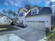 Inviting home featuring a two-car garage, covered porch, and beautifully maintained lawn at 69 Azul Dr, Clayton, NC 27520