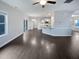 Open-concept living space with dark wood floors, a view of the kitchen, and plenty of natural light at 69 Azul Dr, Clayton, NC 27520