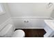 Cozy powder room featuring paneled walls, a toilet, and a pedestal sink at 69 Azul Dr, Clayton, NC 27520