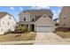 Charming two-story home boasts a well-maintained front yard and an attached two-car garage at 717 Tailrace Falls Ct, Wake Forest, NC 27587