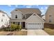 Charming two-story home boasts a well-maintained front yard and an attached two-car garage at 717 Tailrace Falls Ct, Wake Forest, NC 27587