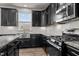 Modern kitchen features black cabinets, granite countertops, stainless steel appliances, and a center island at 717 Tailrace Falls Ct, Wake Forest, NC 27587