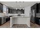 Modern kitchen with dark cabinetry, stainless steel appliances, a granite countertop island, and sleek white subway tile backsplash at 717 Tailrace Falls Ct, Wake Forest, NC 27587
