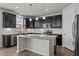 Modern kitchen features black cabinets, granite countertops, stainless steel appliances, and a center island at 717 Tailrace Falls Ct, Wake Forest, NC 27587