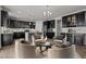 Entertainer's kitchen with a bar featuring dark cabinets, granite countertops, stainless steel appliances, and a cozy lounge area at 717 Tailrace Falls Ct, Wake Forest, NC 27587