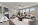 Bright living room featuring a fireplace, neutral tones, large windows, and stylish furniture for a comfortable gathering space at 717 Tailrace Falls Ct, Wake Forest, NC 27587