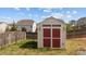 Backyard shed with red doors, providing extra storage space at 717 Tailrace Falls Ct, Wake Forest, NC 27587