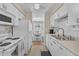 Bright kitchen features white appliances, cabinets and a view into the adjacent dining area at 7305 Sandy Creek Dr, Raleigh, NC 27615
