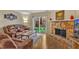 Comfortable living room with stone fireplace, sliding glass doors to the patio, and wood floors at 7305 Sandy Creek Dr, Raleigh, NC 27615